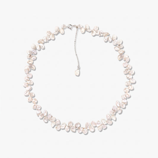 Collana in argento sterling con perle coltivate bianche barocche irregolari disposte a cerchio su sfondo bianco, con catena regolabile e ciondolo a perla pendente.