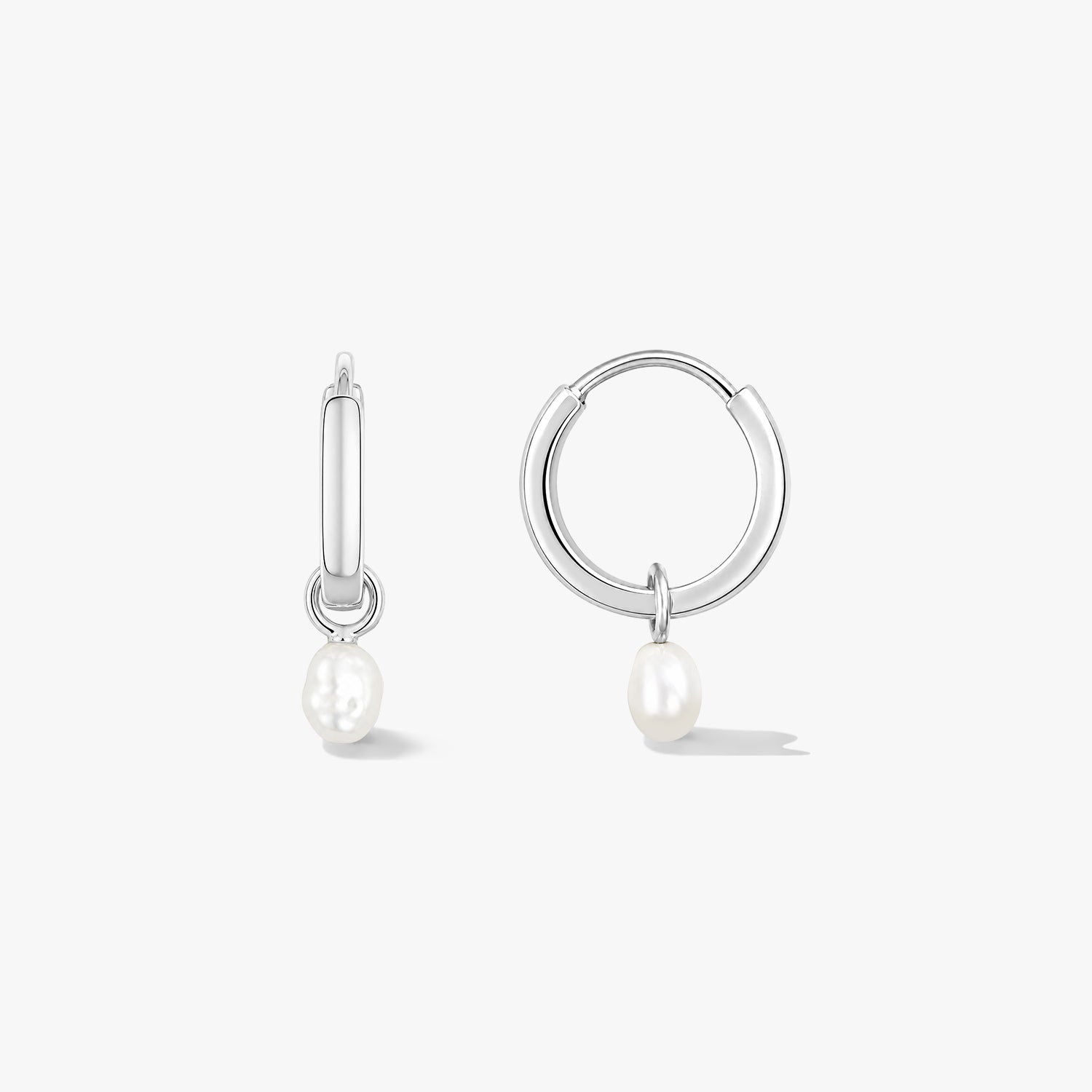 Coppia di orecchini a cerchio in argento sterling con piccole gocce di perla naturale su sfondo bianco, uno in vista frontale e uno in vista laterale.