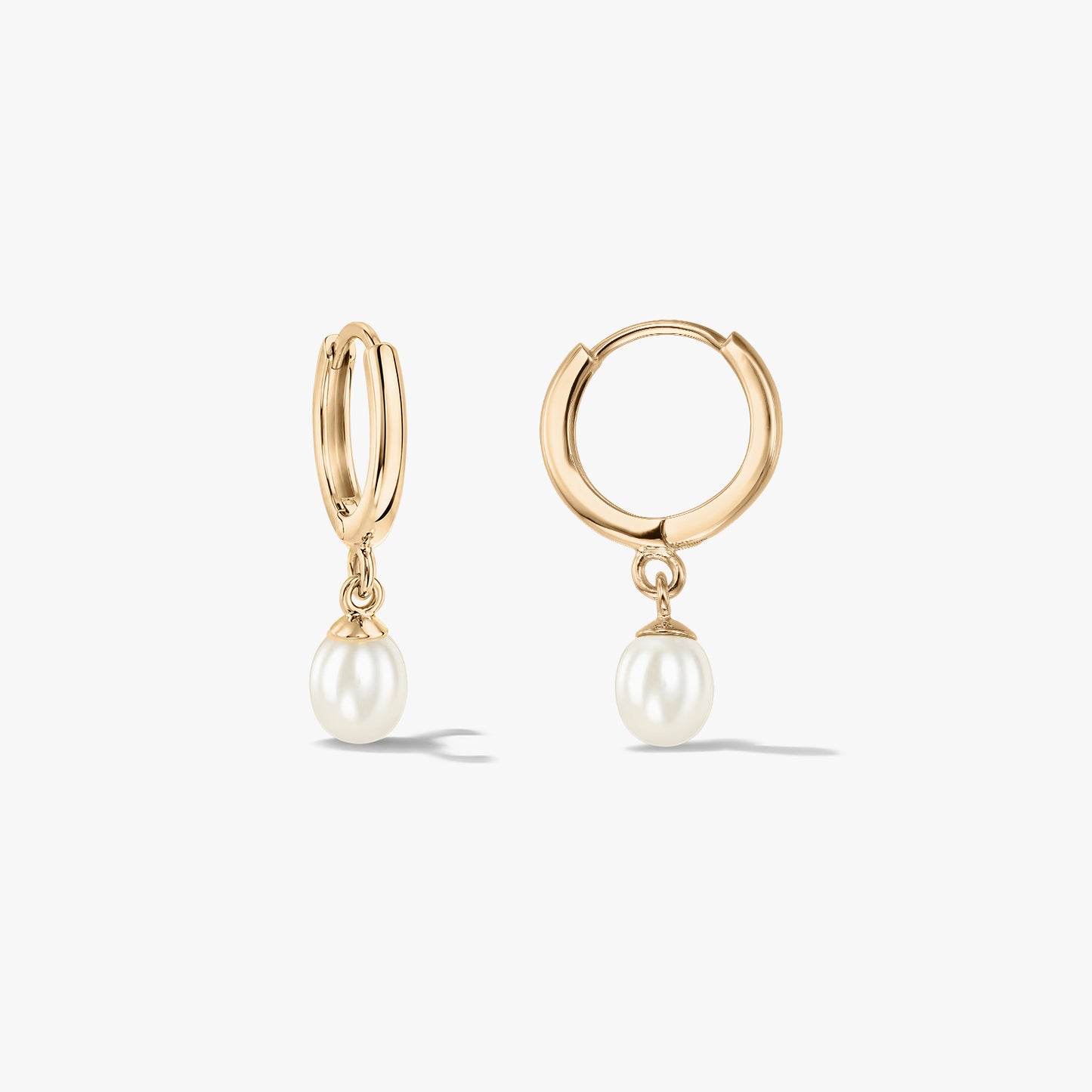 Coppia di orecchini a cerchio in oro giallo 14K con pendenti di perle naturali su sfondo bianco.