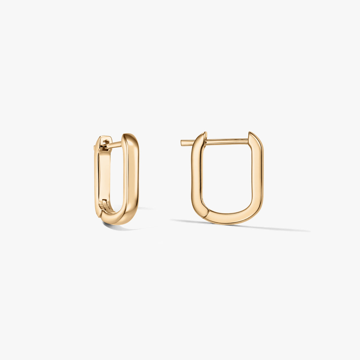 Paio di orecchini a cerchio a forma di U in argento sterling placcato oro su sfondo bianco, uno aperto e uno chiuso.