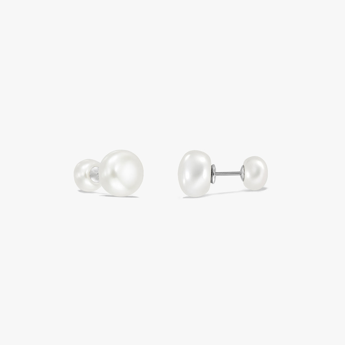 Coppia di orecchini a lobo in argento sterling con doppia perla su sfondo bianco, ciascuno con una grande perla naturale bianca da un lato e una più piccola dall’altro, collegate da un perno.