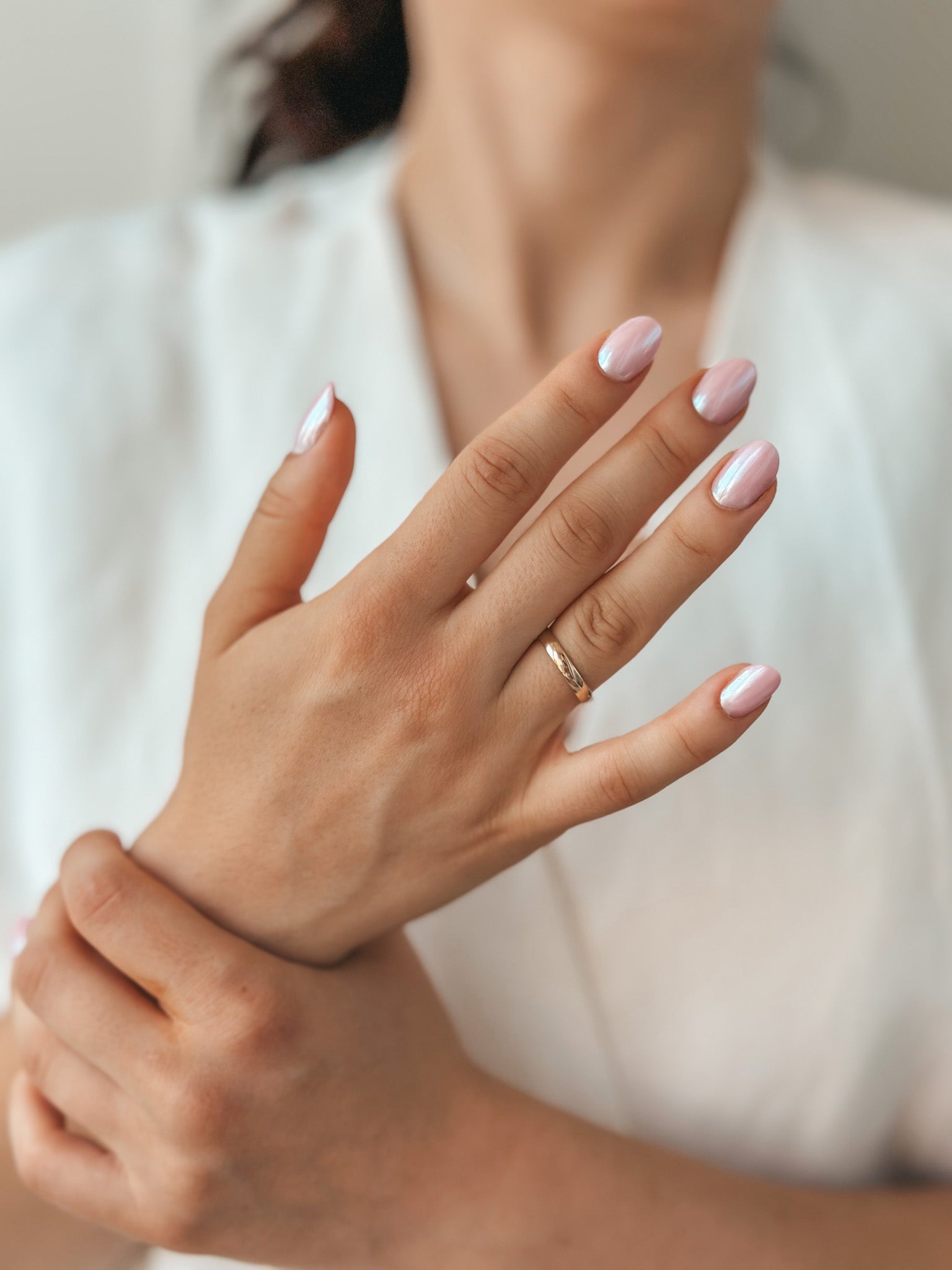 Close-up of hands with a gold wedding band and polished nails