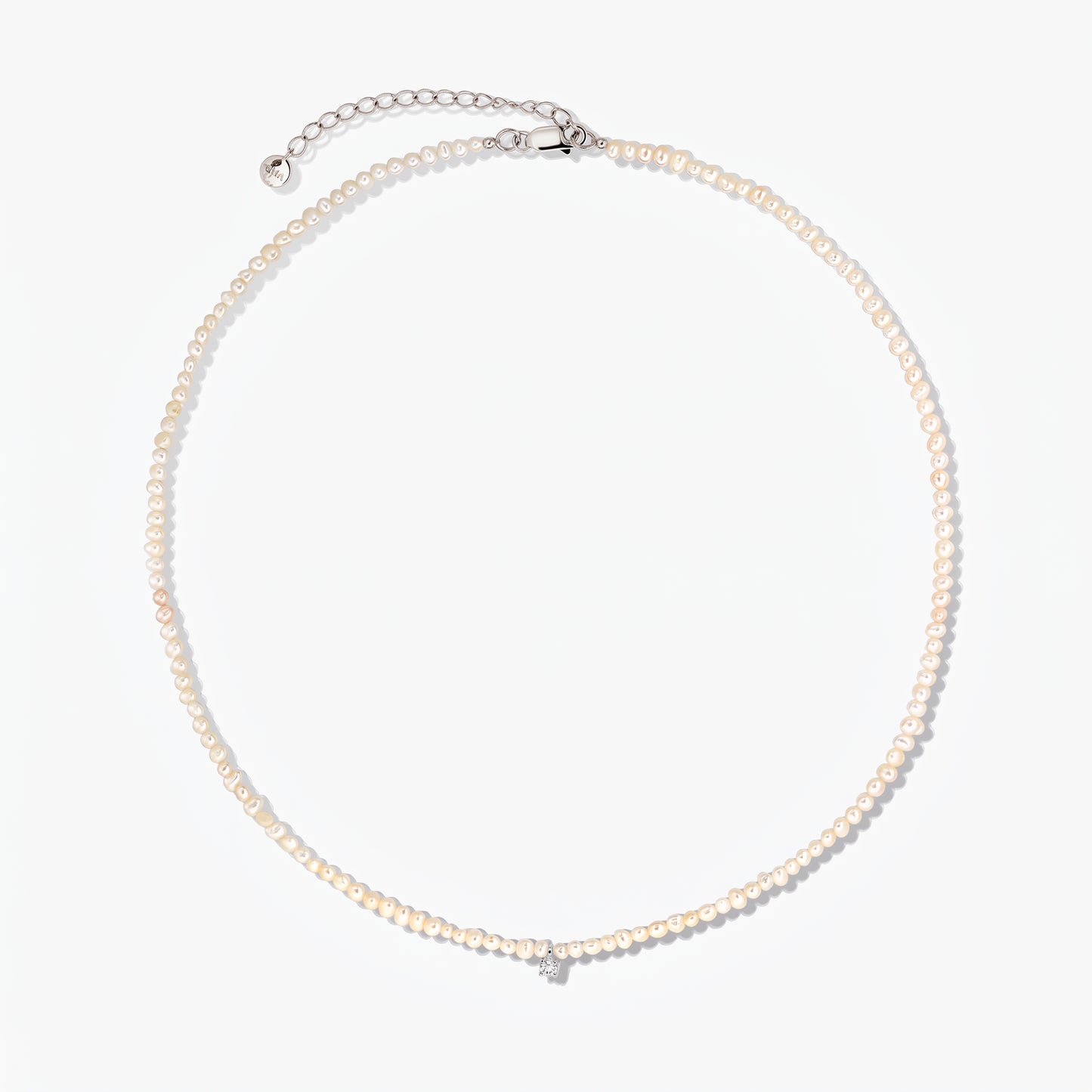 Collana Fairy in argento con piccole perle coltivate e catena di prolunga regolabile, fotografata su sfondo bianco.