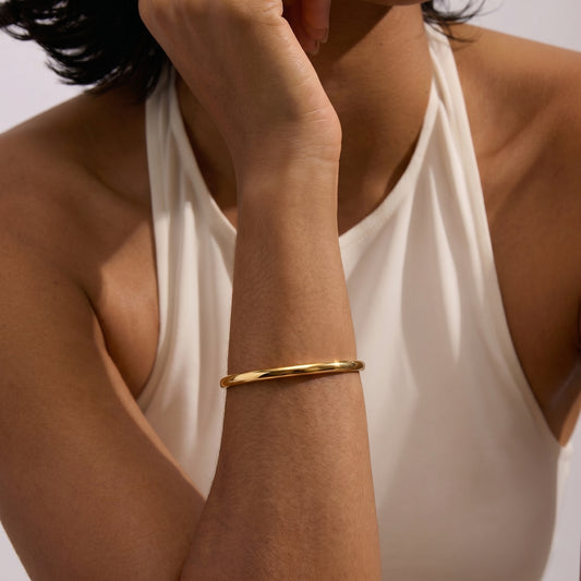 Primo piano di una persona che indossa un Bracciale Serena in Oro e Argento al polso su uno sfondo chiaro.