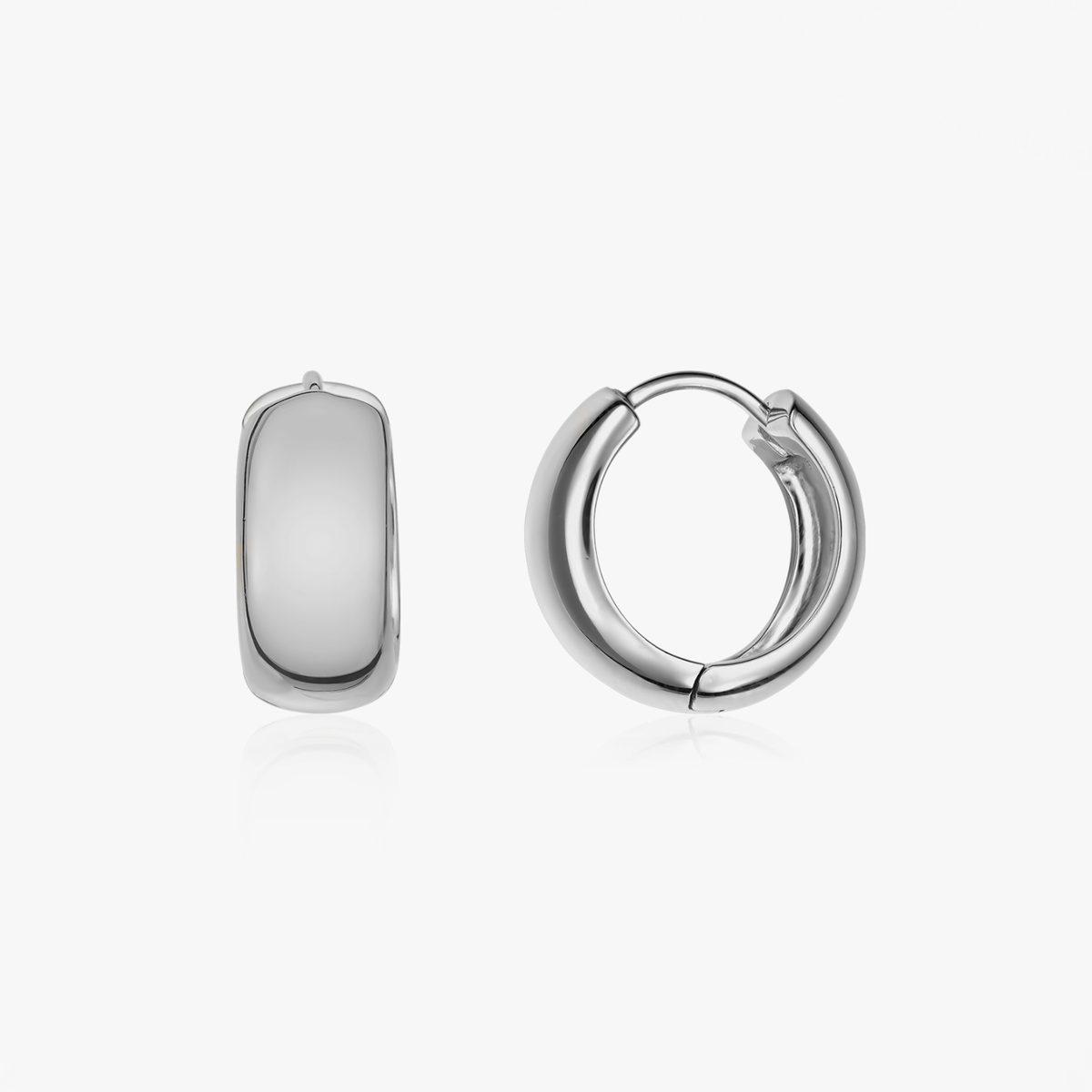 Paio di orecchini a cerchio in argento dal design audace su sfondo bianco.