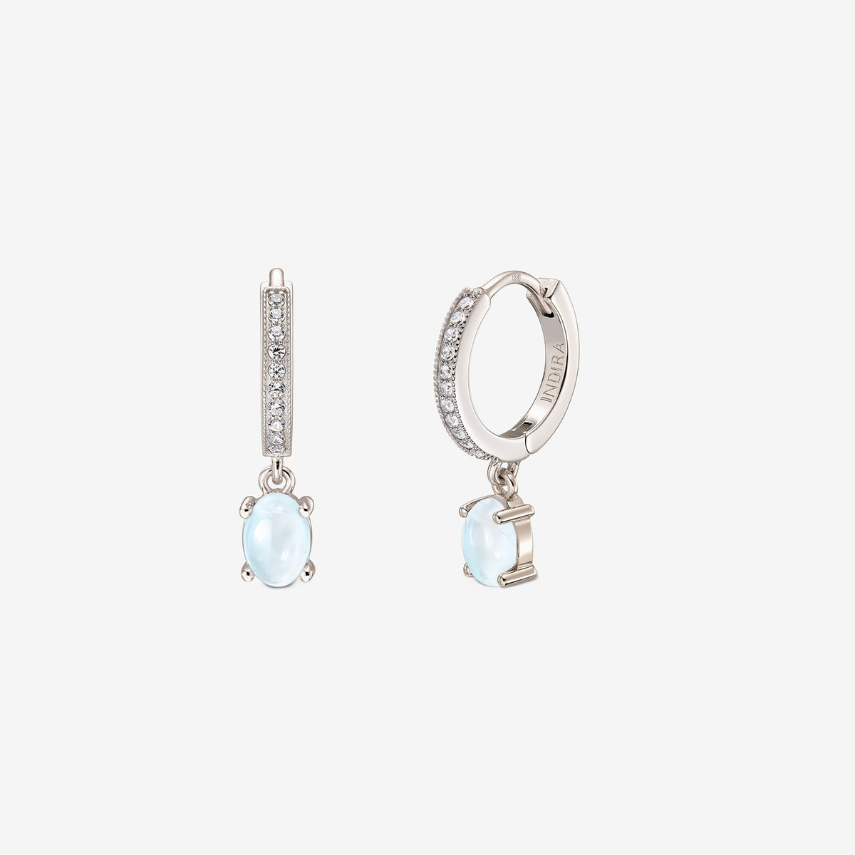Coppia di orecchini a cerchio huggie in argento sterling con frontali pavé e pendenti ovali in pietra di luna cabochon su sfondo bianco.