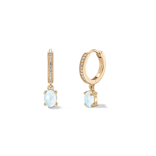 Coppia di orecchini a cerchio huggie in argento 925 con finitura color oro, dettagli pavé e pendenti a goccia di pietra di luna ovale su sfondo bianco.