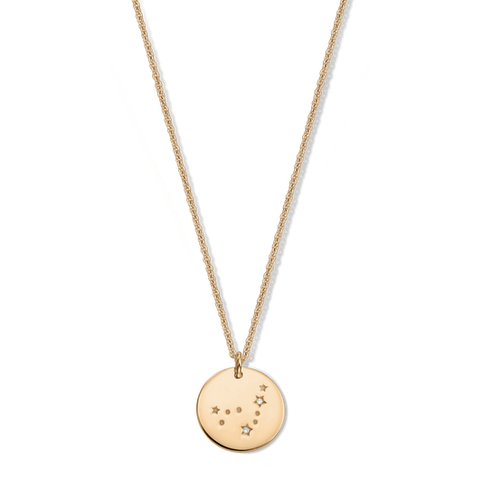 Collana zodiacale in argento 925 con finitura dorata con ciondolo rotondo a costellazione del Capricorno, impreziosito da piccoli accenti di zaffiro bianco, isolata su sfondo trasparente.