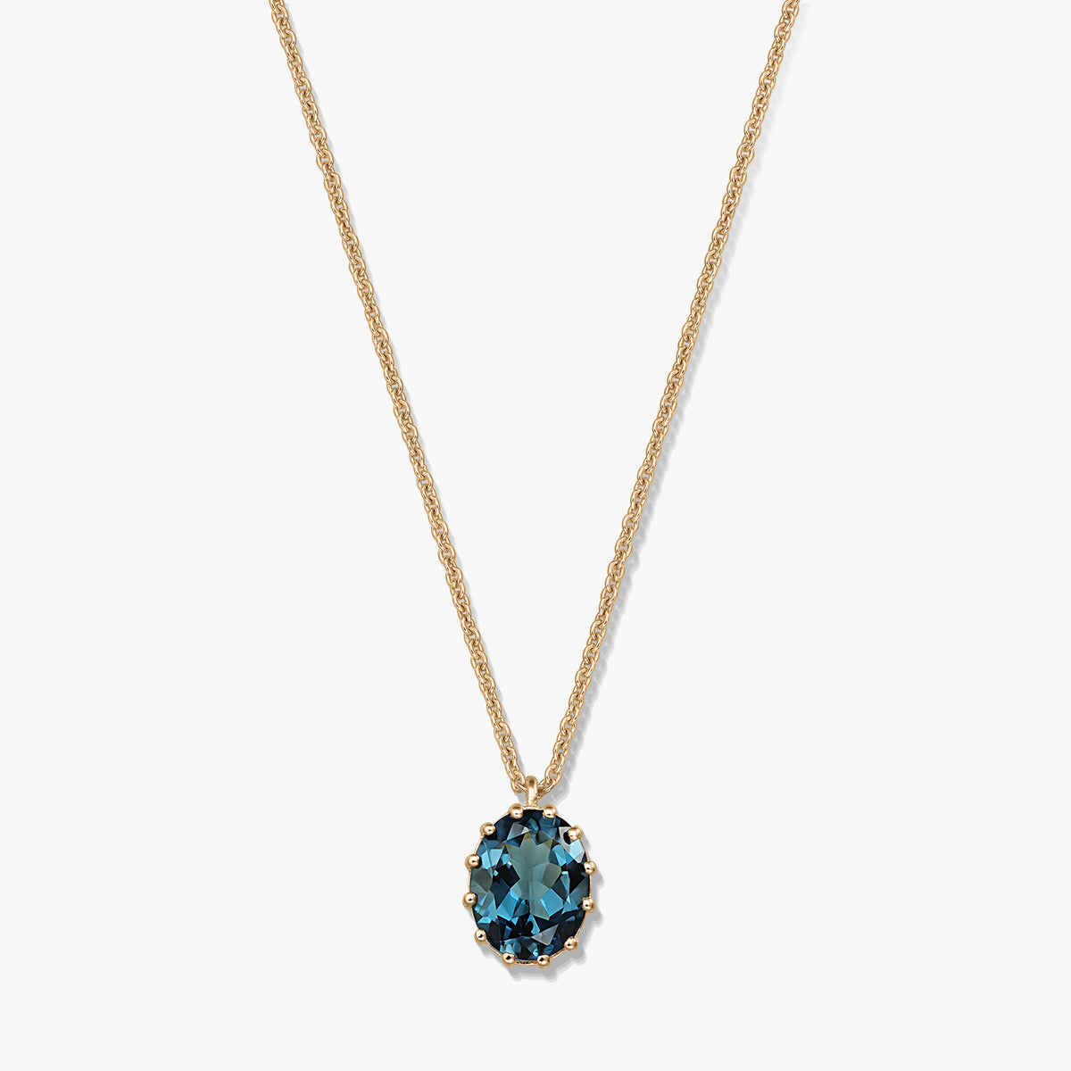 Delicata collana in argento sterling placcato oro con pendente ovale in topazio London Blue su sfondo bianco.