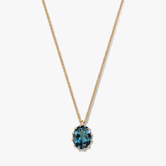 Delicata collana in argento sterling placcato oro con pendente ovale in topazio London Blue su sfondo bianco.