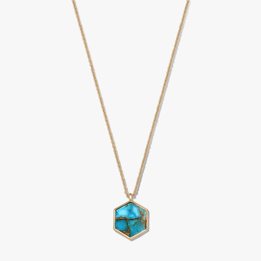 Collana in argento sterling placcato oro con pendente esagonale in rame color turchese, su sfondo bianco.