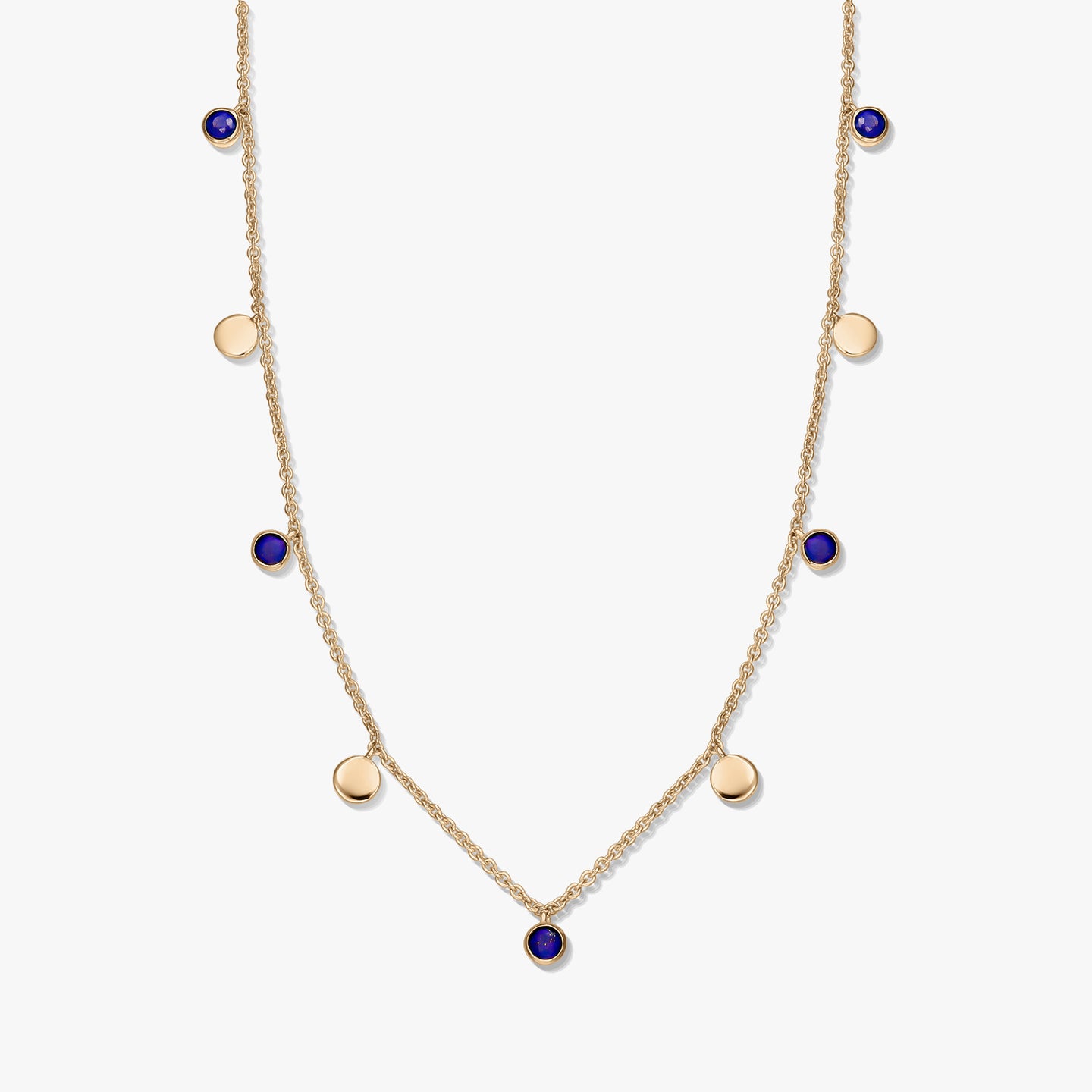 Collana a stazioni in argento 925 placcato oro con cabochon rotondi in lapislazzuli e piccoli ciondoli a disco dorati su una catena delicata, fotografata su sfondo bianco.