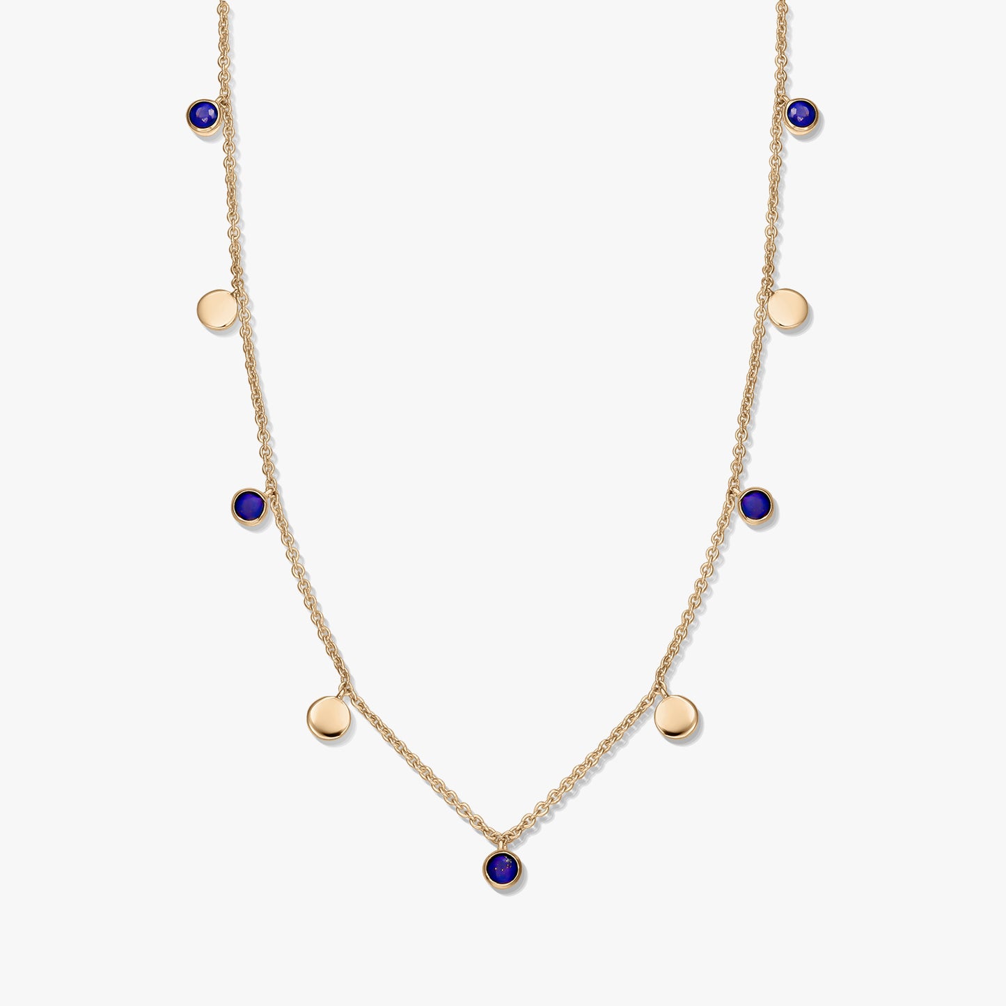 Collana a stazioni in argento 925 placcato oro con cabochon rotondi in lapislazzuli e piccoli ciondoli a disco dorati su una catena delicata, fotografata su sfondo bianco.