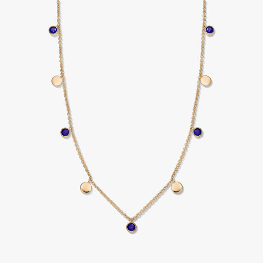 Collana a stazioni in argento 925 placcato oro con cabochon rotondi in lapislazzuli e piccoli ciondoli a disco dorati su una catena delicata, fotografata su sfondo bianco.