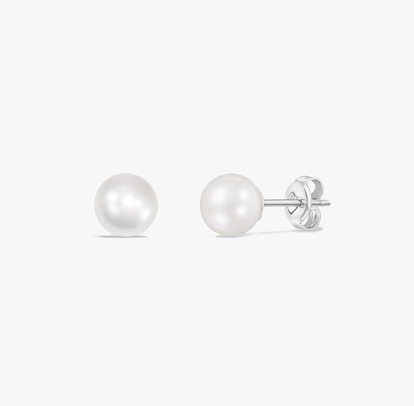 Coppia di orecchini a lobo classici con perle bianche naturali montate in argento sterling 925 su sfondo bianco.