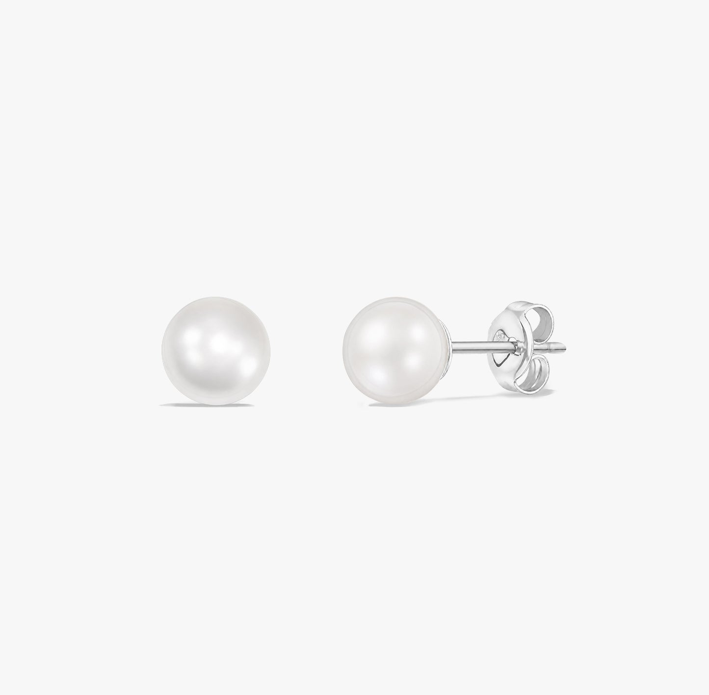 Coppia di orecchini a lobo classici con perle bianche naturali montate in argento sterling 925 su sfondo bianco.