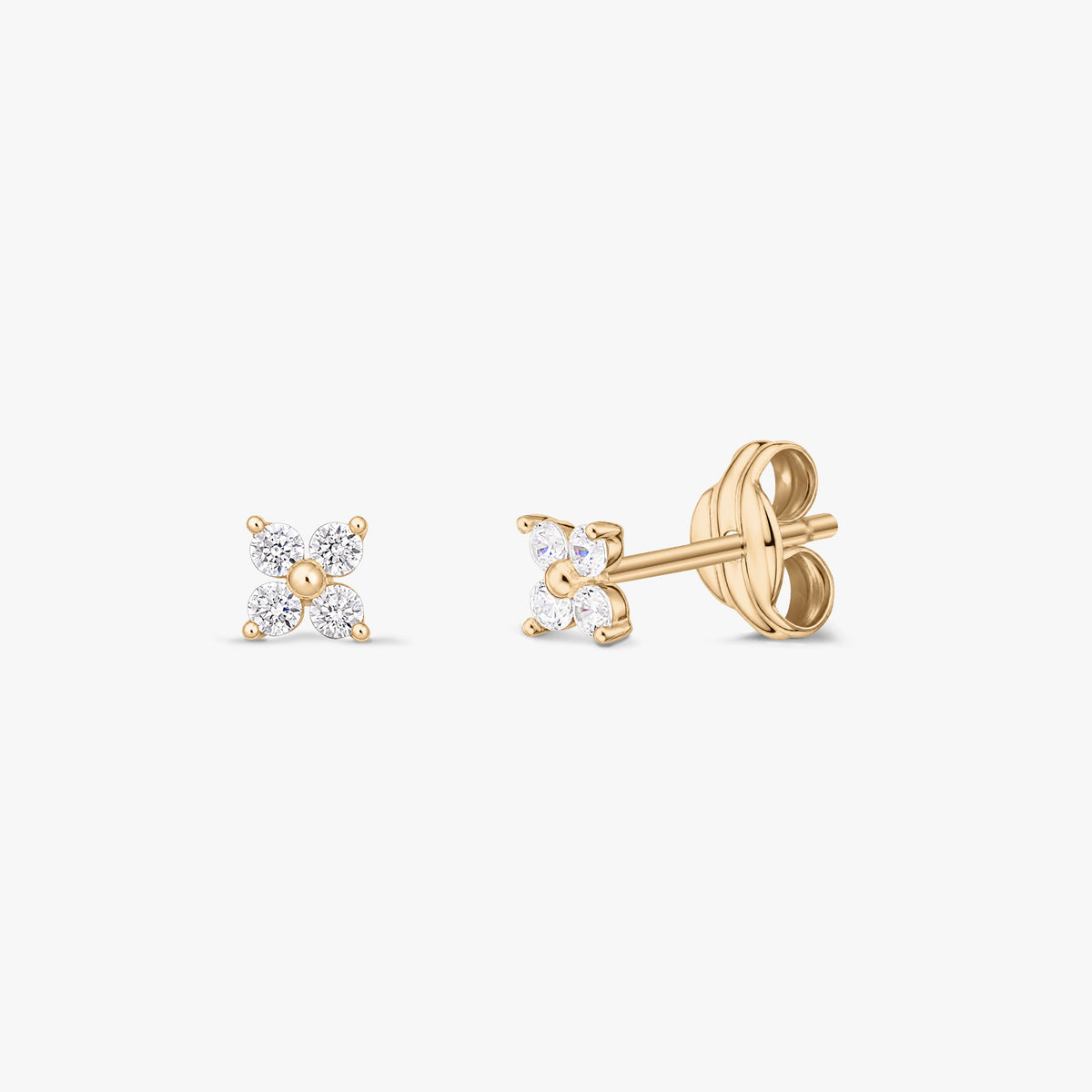 Coppia di orecchini a perno in oro giallo 14K con quattro zirconi trasparenti a forma di piccolo fiore, mostrati frontalmente e di lato su sfondo bianco.