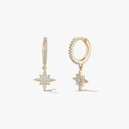Coppia di orecchini huggie a cerchio in argento placcato oro con charm a stella raggiante con pavé di zirconi, su sfondo bianco.
