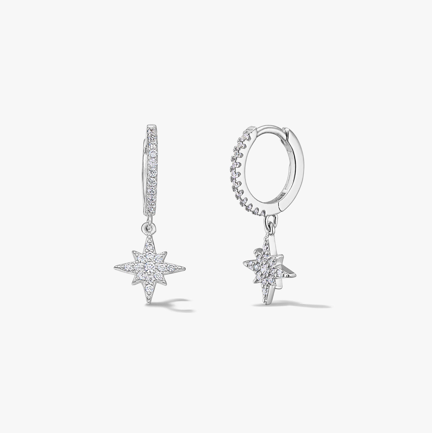 Coppia di orecchini a cerchio in argento sterling con ciondoli Stella Polare in zirconia pavé su sfondo bianco.