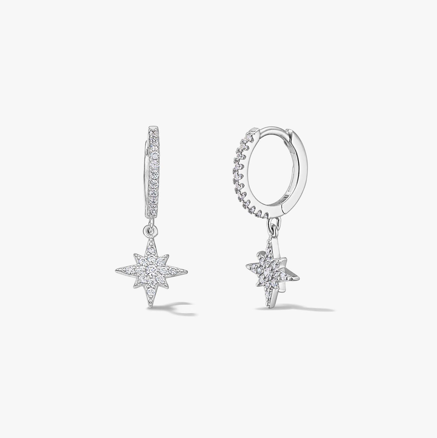Coppia di orecchini a cerchio in argento sterling con ciondoli Stella Polare in zirconia pavé su sfondo bianco.
