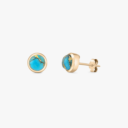 Coppia di orecchini a lobo con cabochon tondi di turchese in argento 925 placcato oro, montatura a castone e chiusura a farfalla, su sfondo bianco.