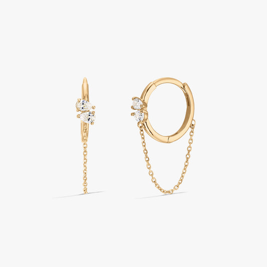 Orecchini a cerchio in oro eleganti con pietre di zirconia e un dettaglio a catena su sfondo bianco.