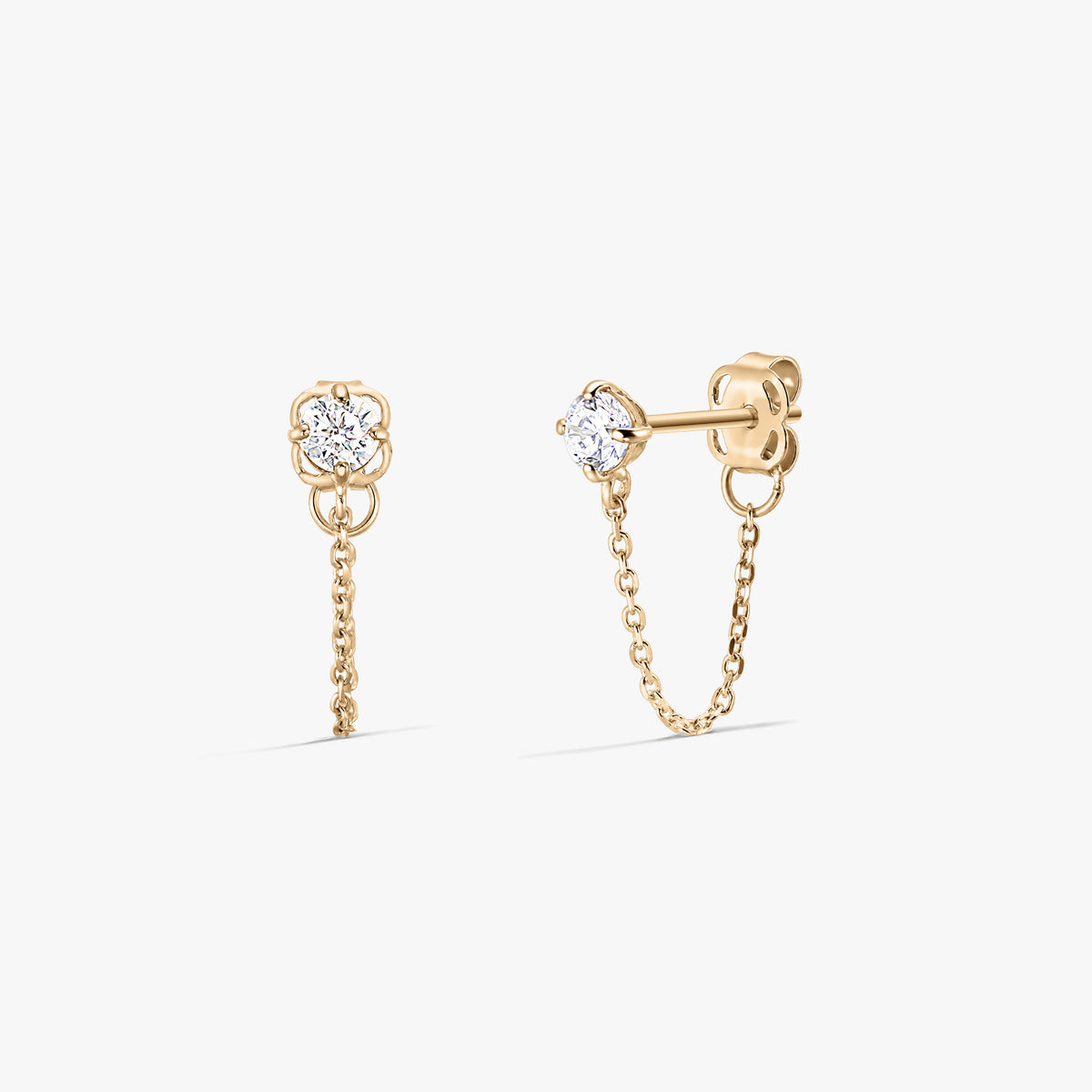 Coppia di orecchini a lobo Emma in oro con pietre di zirconia trasparente e delicati pendenti a catena, mostrati fronte e lato su sfondo bianco.