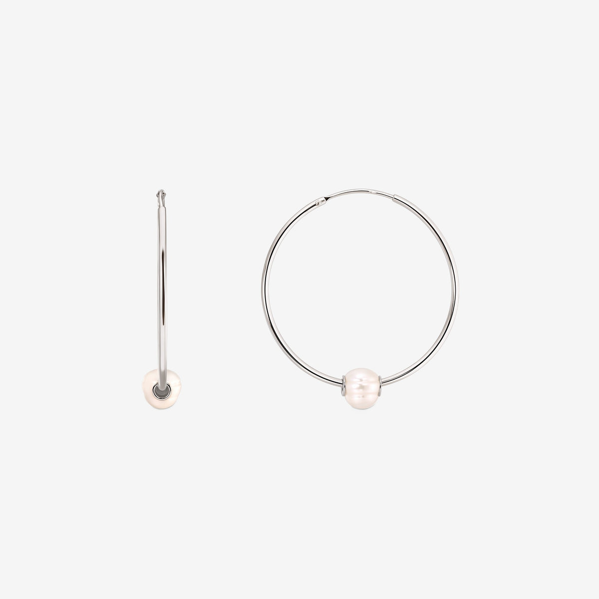 Coppia di orecchini a cerchio in argento sterling con una singola perla coltivata bianca su ciascuno, mostrati su sfondo bianco con un orecchino vista frontale e uno vista laterale.