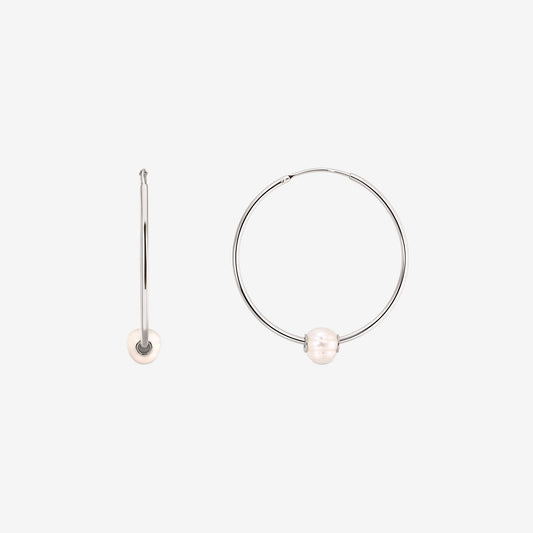 Coppia di orecchini a cerchio in argento sterling con una singola perla coltivata bianca su ciascuno, mostrati su sfondo bianco con un orecchino vista frontale e uno vista laterale.
