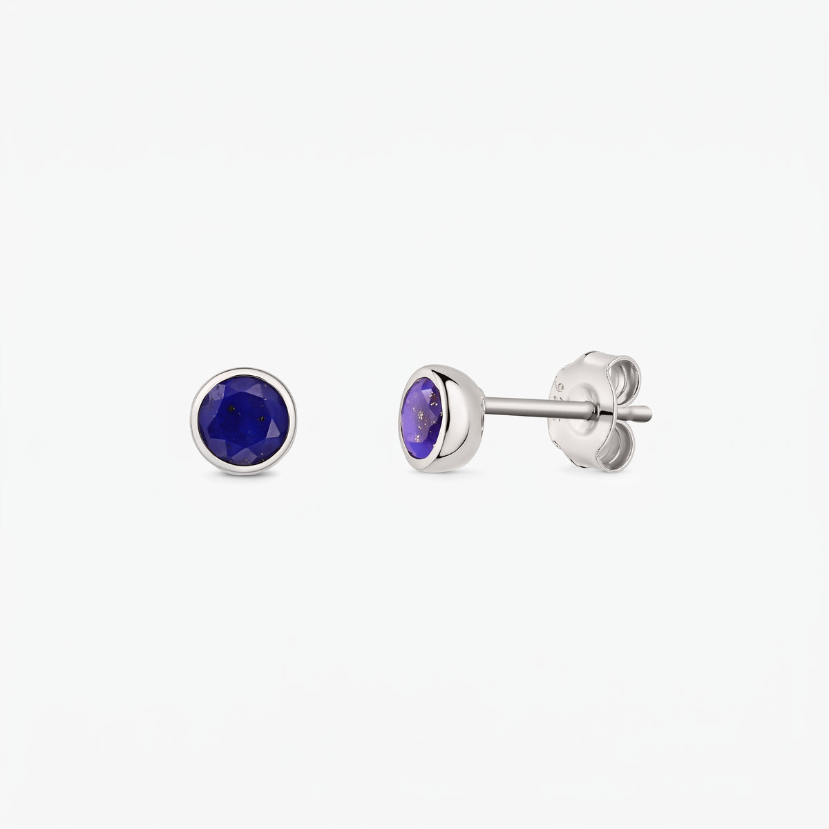 Orecchini a bottone in argento sterling con pietre lapislazzuli rotonde sfaccettate; un orecchino mostrato frontalmente e l'altro di profilo con fermaglio a farfalla su sfondo bianco.