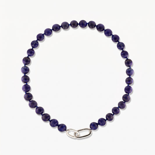 Foto quadrata in studio della collana Mareille in argento con perle rotonde di lapislazzuli e chiusura a maglia liscia in argento su sfondo bianco.