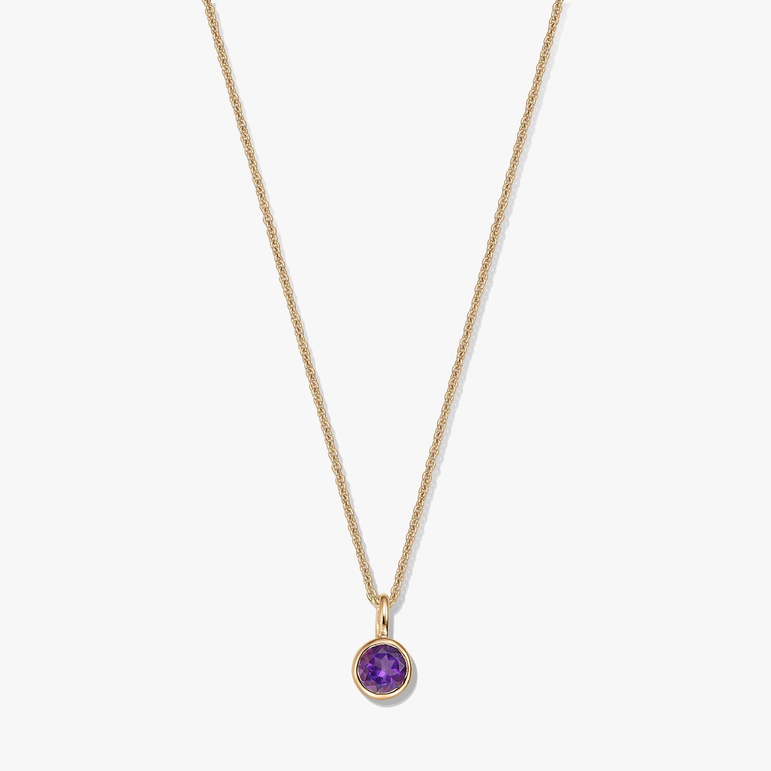 Collana in argento sterling placcato oro con un piccolo pendente rotondo con ametista come pietra di nascita su sfondo bianco.