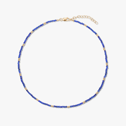 Collana a perline di lapislazzuli con piccoli dettagli in argento sterling placcato oro e chiusura a moschettone regolabile, su sfondo bianco.