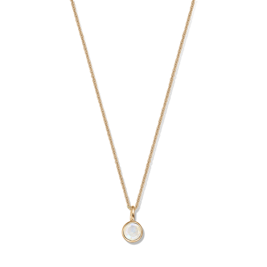 Delicato collana in argento sterling placcato oro con pendente in pietra di luna rotonda in castone su sfondo nero.