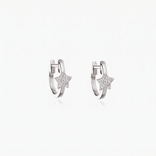 Coppia di orecchini a cerchio huggie in argento sterling 925 placcato rodio con piccoli ciondoli a stella impreziositi da zirconia trasparente, su sfondo bianco.
