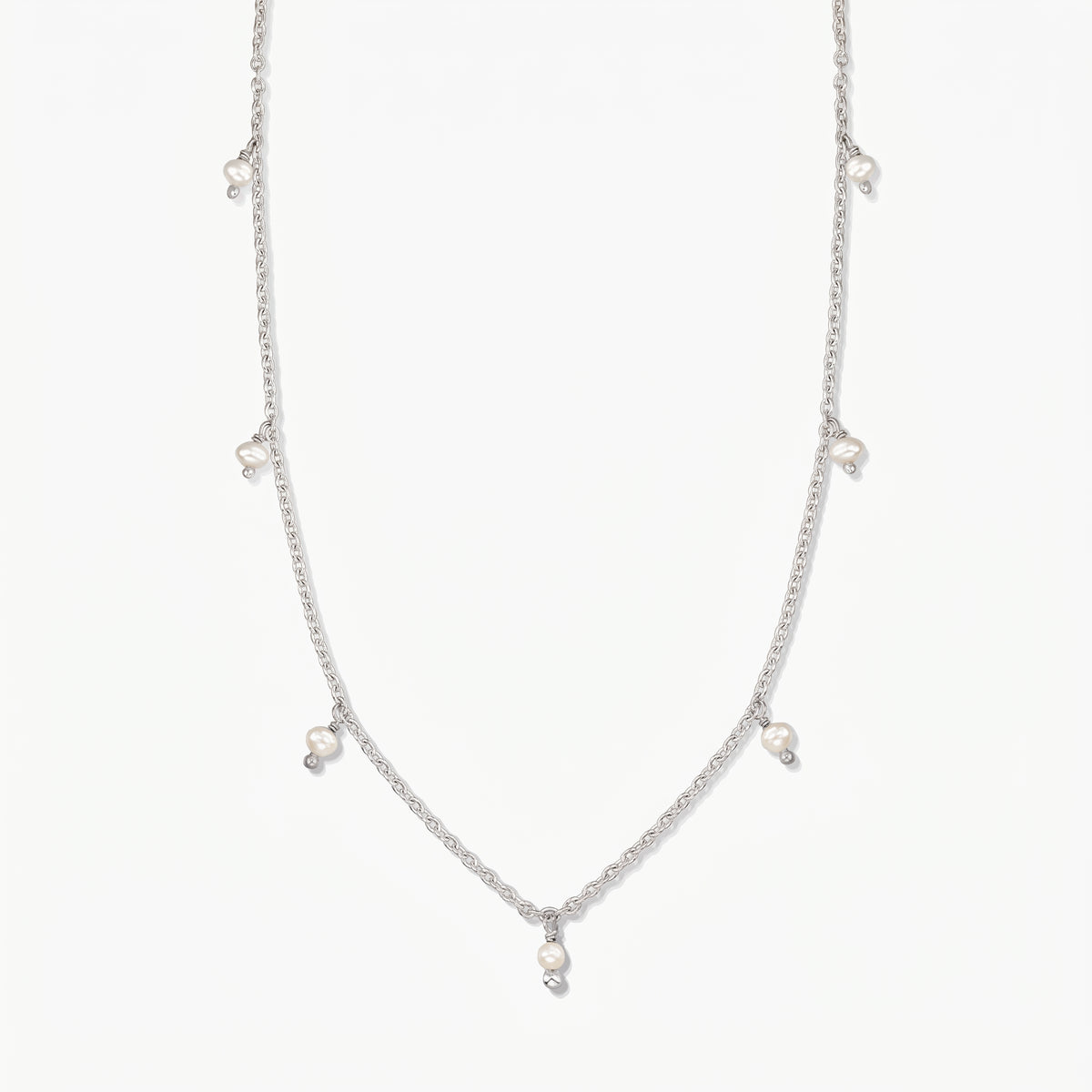 Collana in argento Indira Margot con piccole gocce di perla naturale, fotografata su uno sfondo bianco pulito.