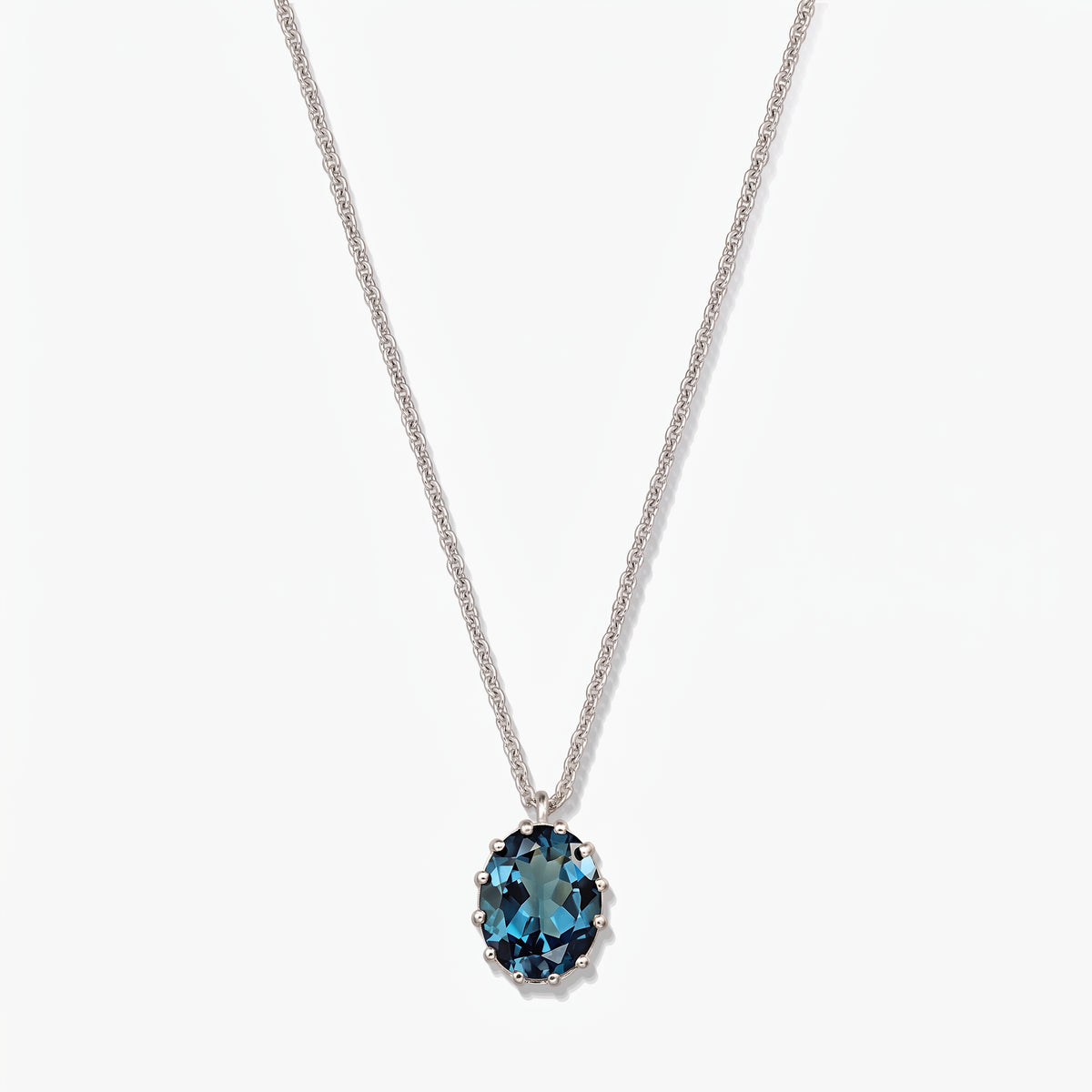 Collana in argento sterling con pendente ovale in topazio London blue su sfondo bianco.