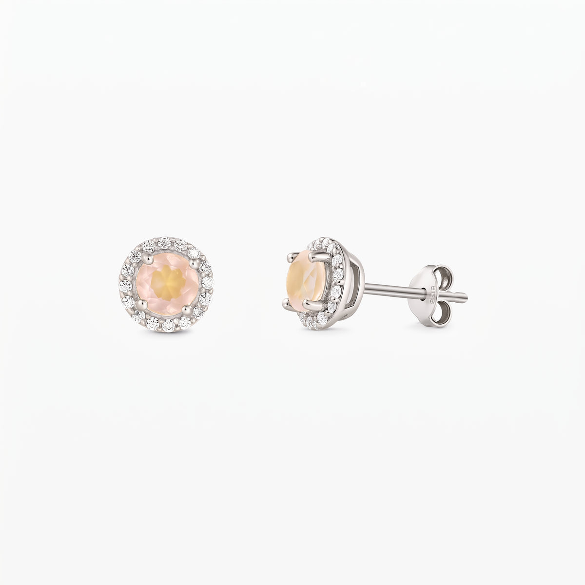 Coppia di orecchini a lobo in argento sterling con centri rotondi in quarzo rosa e contorno di zirconi, mostrati frontalmente e di profilo su sfondo bianco.