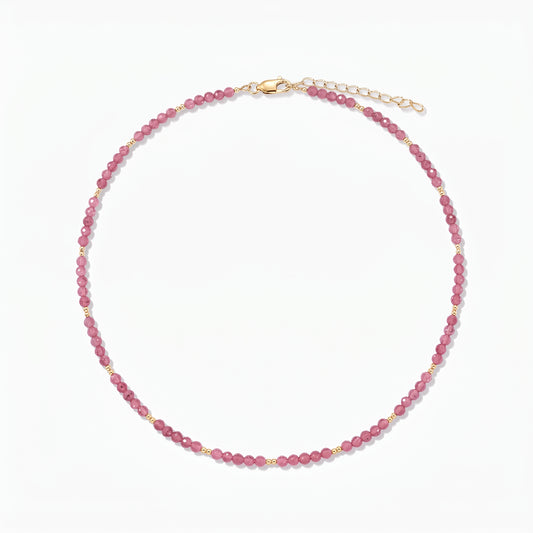 Collana in argento Golden SummerScape - Tourmaline by Indira: collana di perline in tormalina rosa con piccoli dettagli in oro e chiusura a moschettone con prolunga, su sfondo bianco.