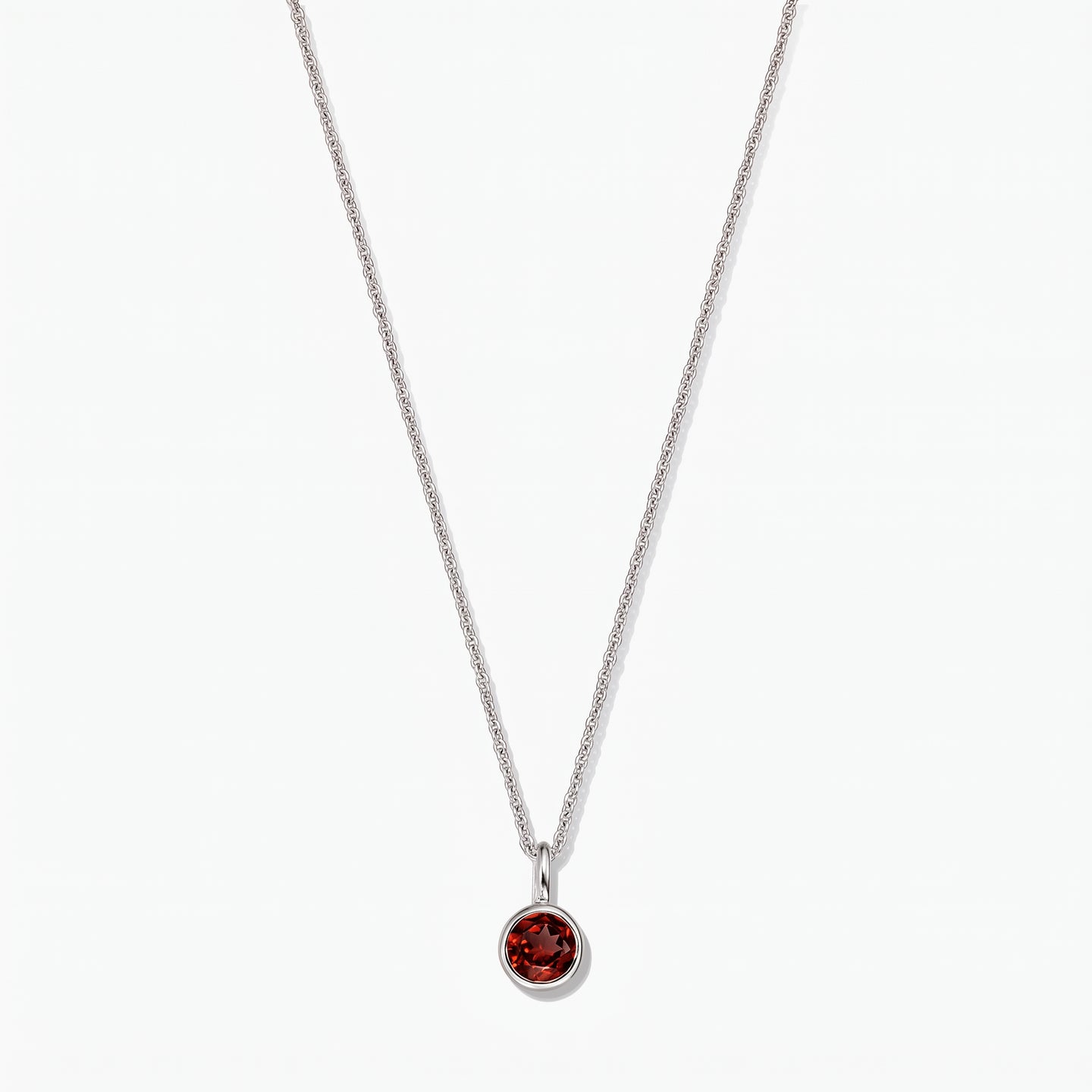 Collana in argento sterling con pietra di nascita, ciondolo in granato rotondo con montatura a castone, su sfondo bianco.