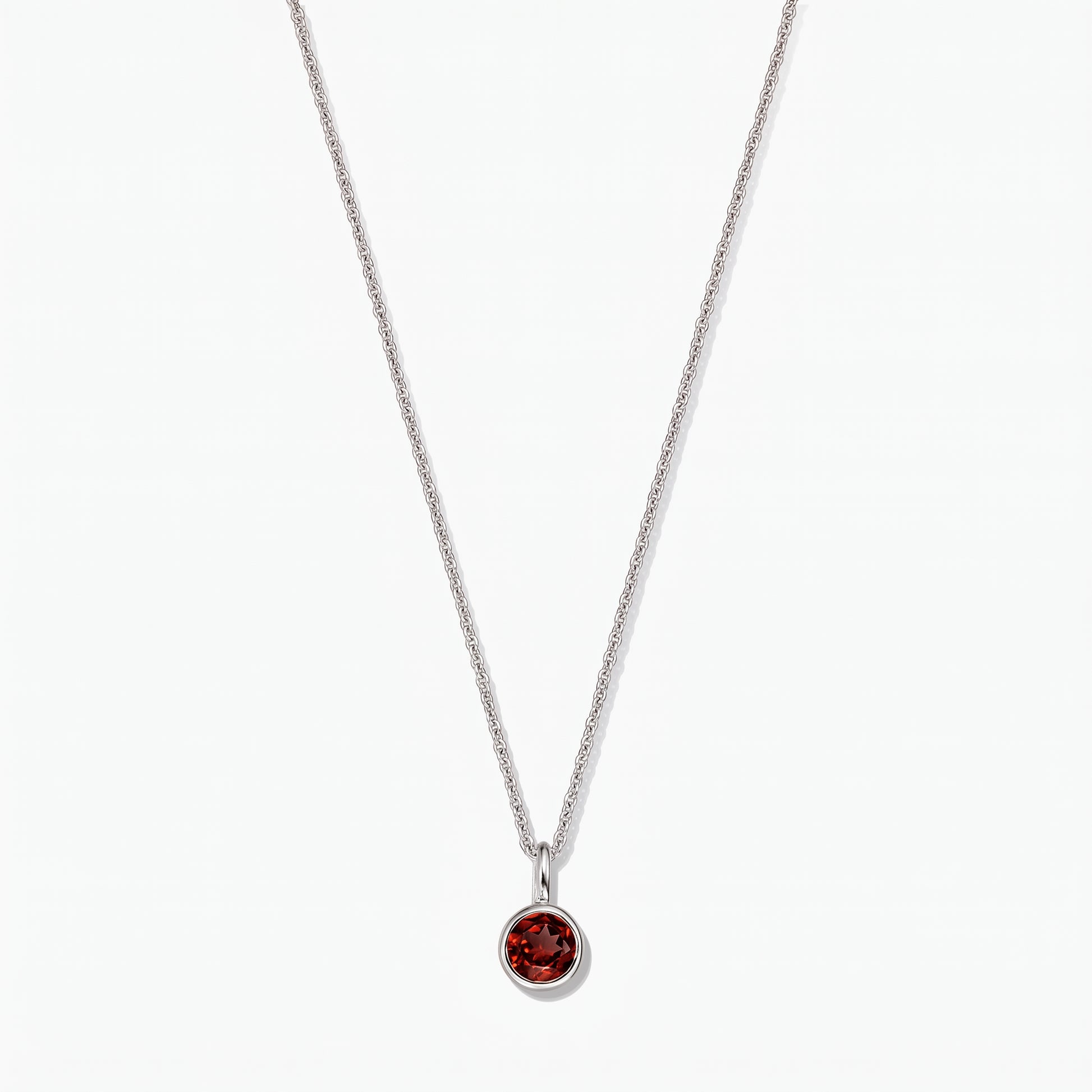 Collana in argento sterling con pietra di nascita, ciondolo in granato rotondo con montatura a castone, su sfondo bianco.