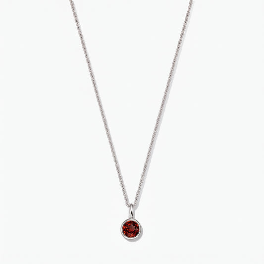 Collana in argento sterling con pietra di nascita, ciondolo in granato rotondo con montatura a castone, su sfondo bianco.