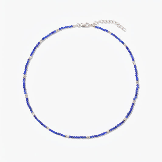 Collana in argento Indira SummerScape con perline in lapislazzuli blu, chiusura a moschettone e catenina di prolunga su sfondo bianco.