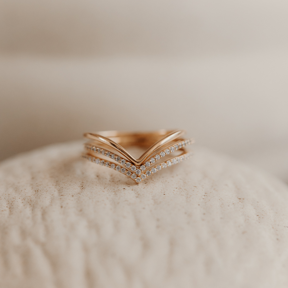 Anello minimalista in argento placcato oro con design stratificato su superficie texturizzata.