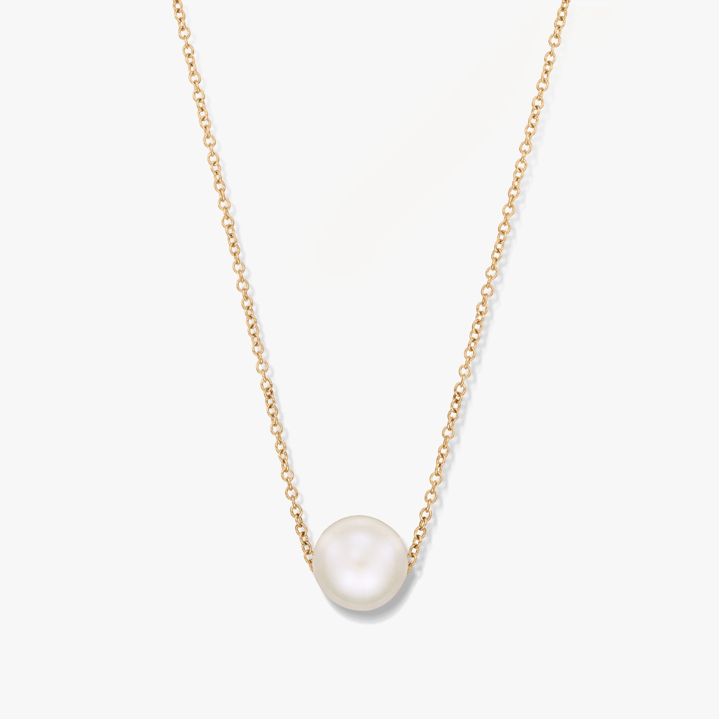 Collana in oro con un ciondolo di perla singola su sfondo bianco.