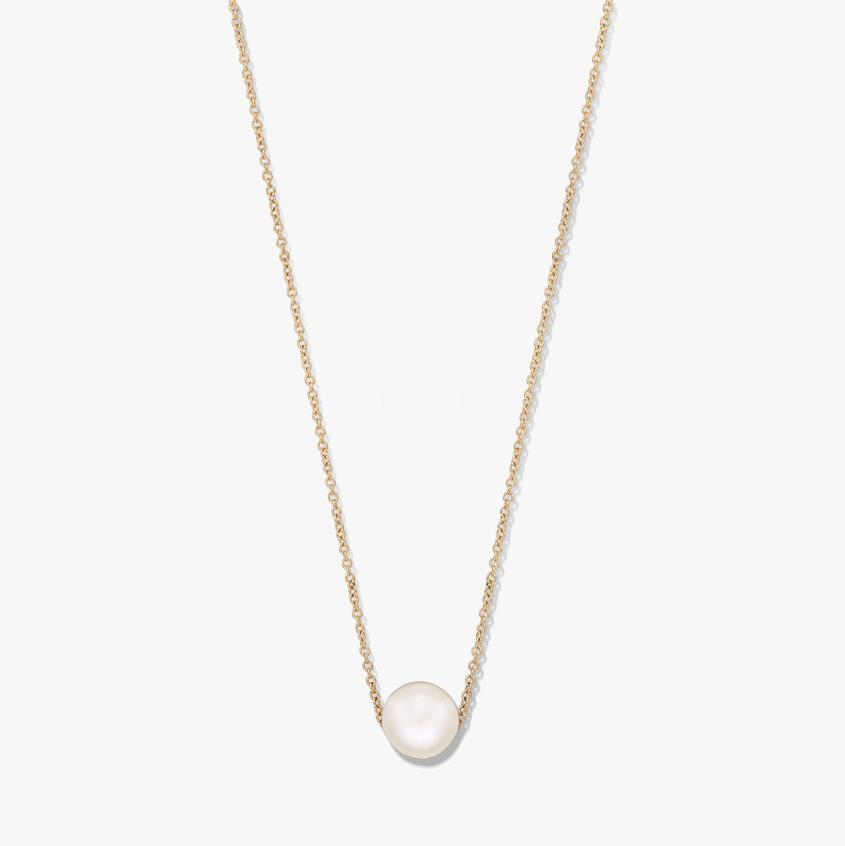 Collana a catena delicata con una singola perla naturale bianca al centro su una catena color oro, isolata su sfondo bianco.