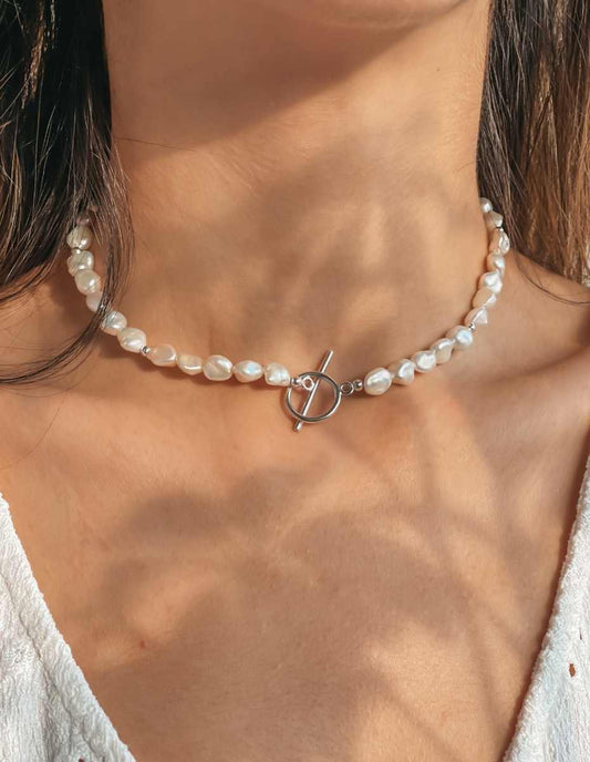Primo piano di una collana di perle naturali con chiusura a levetta in argento.