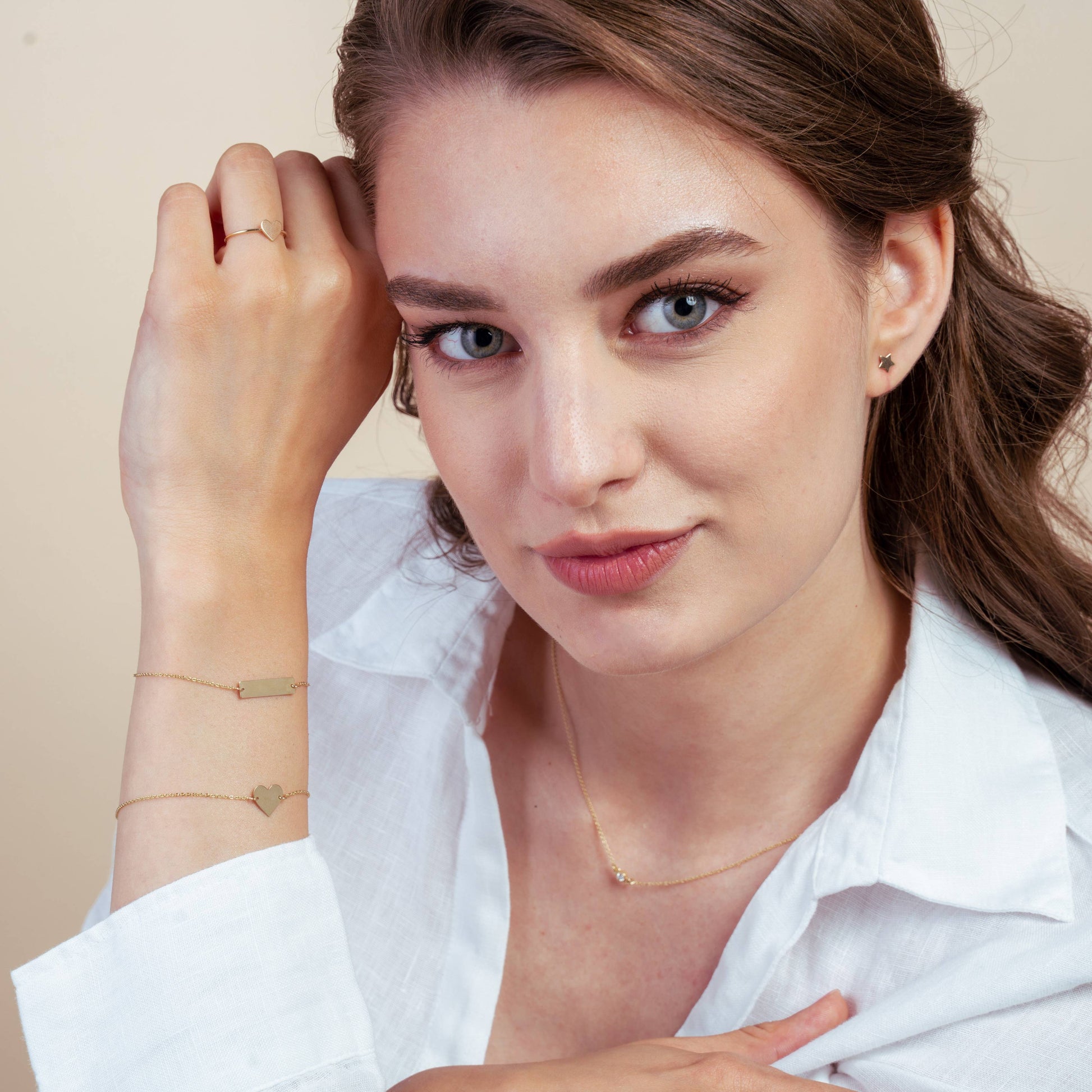 Donna che indossa gioielli in oro tra cui orecchini, braccialetti, collana e anello