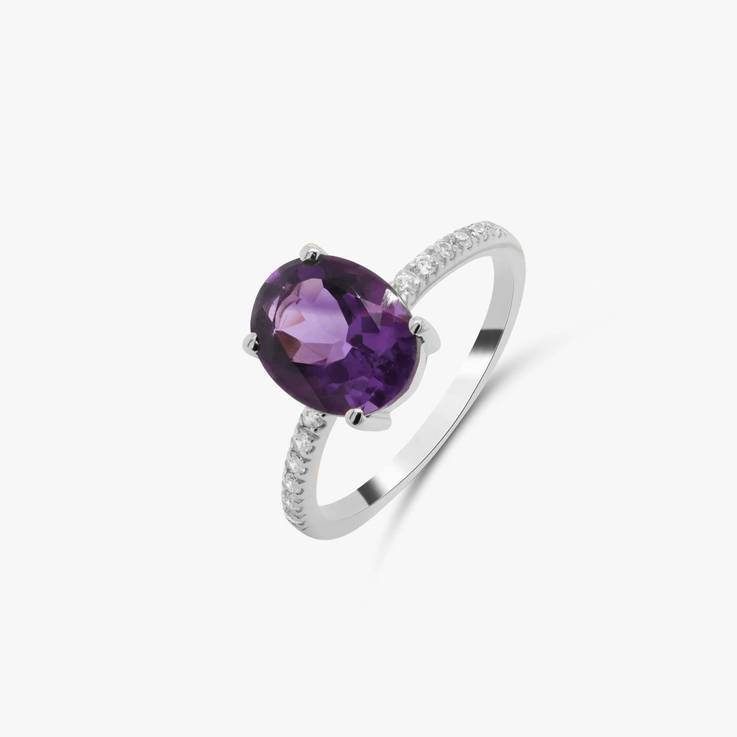 Anello in argento con ametista viola e accenti di zirconi su sfondo bianco.
